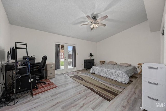 bedroom with a textured ceiling, access to exterior, wood finished floors, and lofted ceiling