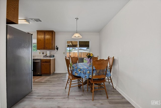 dining room featuring visible vents, plenty of natural light, and light wood-style floors