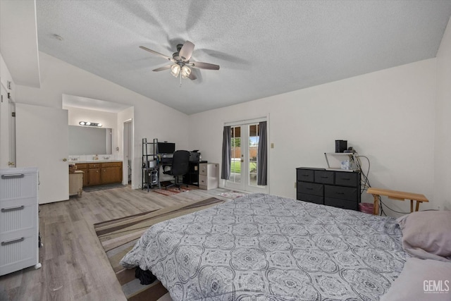 bedroom featuring a textured ceiling, access to exterior, french doors, wood finished floors, and vaulted ceiling