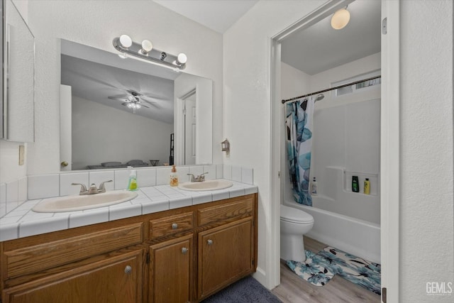 full bathroom featuring double vanity, ceiling fan, a sink, and shower / tub combo with curtain