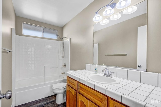 full bathroom featuring toilet, shower / bath combination, wood finished floors, and vanity