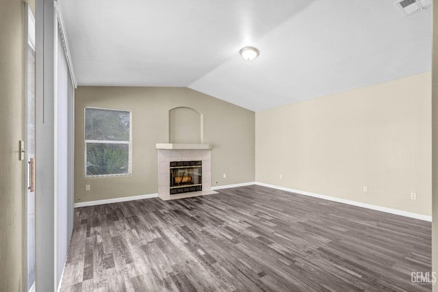 unfurnished living room with baseboards, visible vents, dark wood-style flooring, vaulted ceiling, and a fireplace