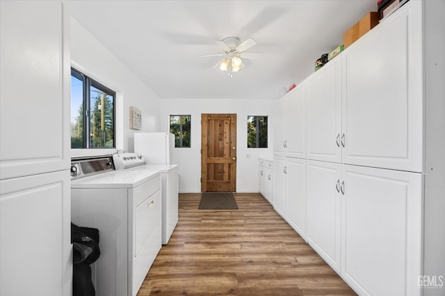 clothes washing area featuring light wood-type flooring, washer and dryer, cabinet space, and ceiling fan