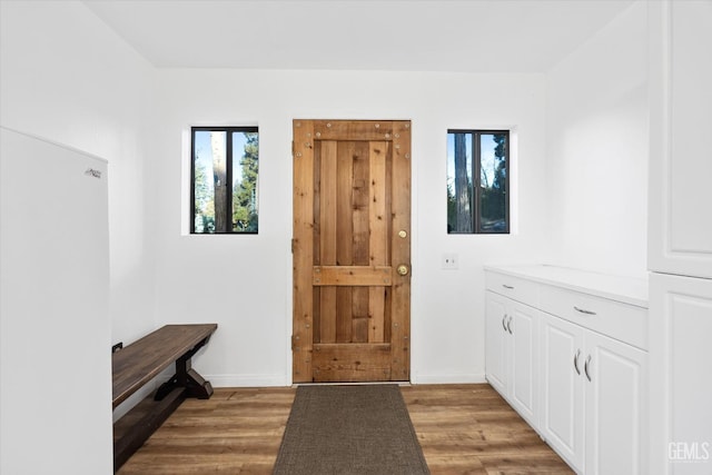 foyer entrance with baseboards and light wood-style floors