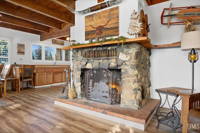 living room with wooden ceiling, beam ceiling, a fireplace, and wood finished floors