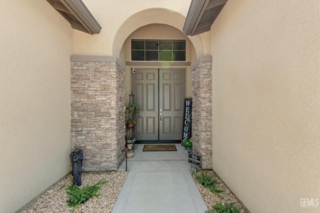 property entrance with stone siding and stucco siding