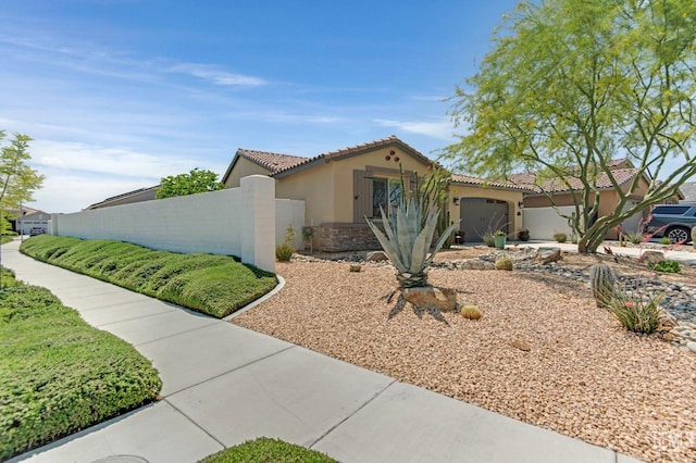 view of front facade with a garage, fence, stone siding, stucco siding, and a tile roof