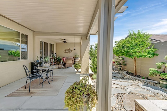 view of patio featuring fence and ceiling fan