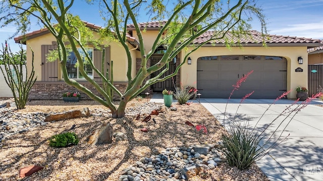 mediterranean / spanish home featuring a tiled roof, an attached garage, driveway, and stucco siding