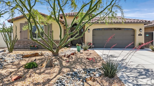 mediterranean / spanish-style home featuring an attached garage, stucco siding, concrete driveway, and a tile roof