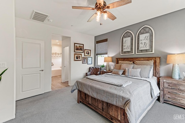 bedroom featuring carpet floors, ceiling fan, visible vents, and ensuite bath