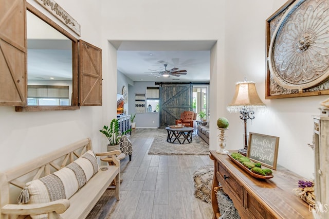 corridor featuring a barn door and wood finished floors