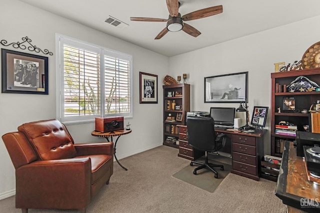 carpeted office space with baseboards, ceiling fan, and visible vents