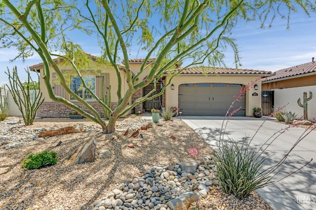 mediterranean / spanish-style home with a garage, stucco siding, driveway, and a tiled roof