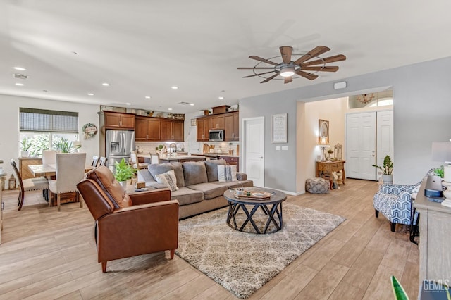 living area with visible vents, light wood-style floors, baseboards, recessed lighting, and a ceiling fan