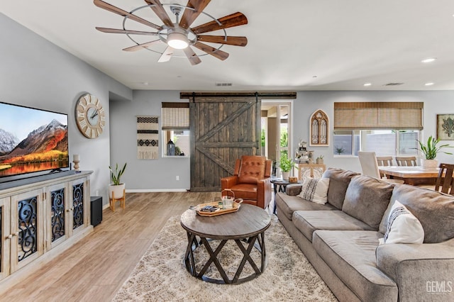 living area with a barn door, light wood finished floors, a ceiling fan, baseboards, and recessed lighting