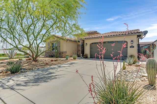 mediterranean / spanish-style house with a garage, stucco siding, driveway, and a tile roof