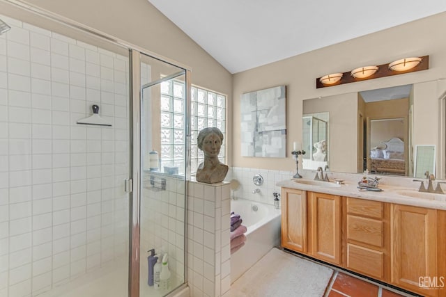 bathroom with tile patterned floors, vanity, shower with separate bathtub, and vaulted ceiling