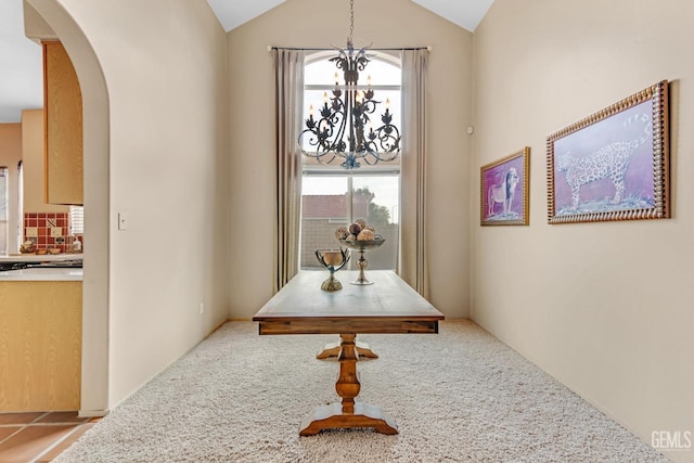 hall featuring light carpet, a chandelier, and vaulted ceiling