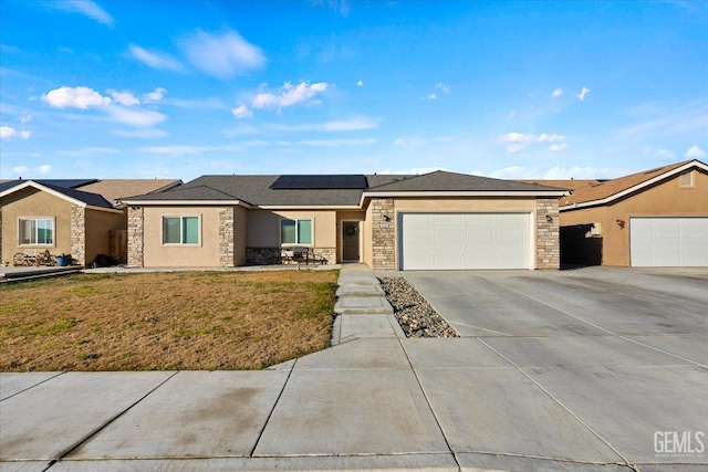 view of front of property with a front lawn, solar panels, and a garage