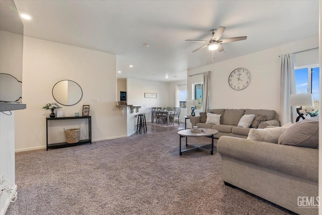 living room featuring ceiling fan, carpet, and a wealth of natural light