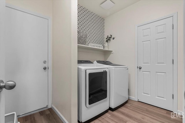 laundry area featuring washer and dryer and light hardwood / wood-style floors