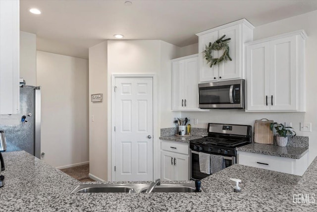 kitchen featuring light stone countertops, sink, white cabinetry, and stainless steel appliances