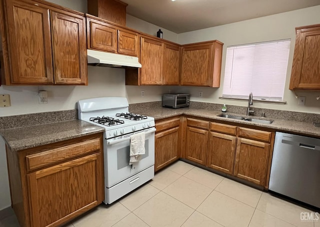 1941 Vassar St, Delano, CA 93215 - kitchen featuring white range with gas stovetop, stainless steel dishwasher, under cabinet range hood, a sink, and brown cabinetry