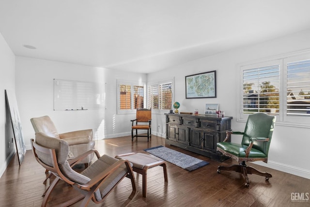 sitting room with baseboards and wood finished floors