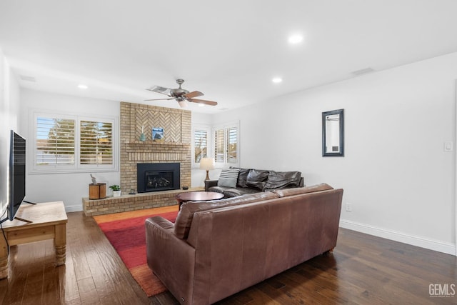 living room with ceiling fan, recessed lighting, baseboards, a brick fireplace, and dark wood-style floors