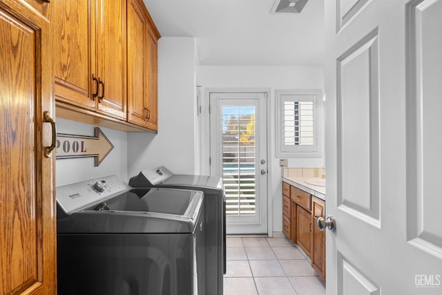 clothes washing area featuring cabinet space, light tile patterned floors, visible vents, and separate washer and dryer