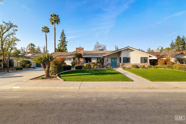 view of front of home featuring a front lawn, concrete driveway, and stucco siding