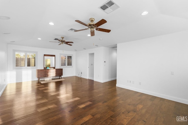 unfurnished living room with baseboards, visible vents, dark wood-style flooring, and recessed lighting