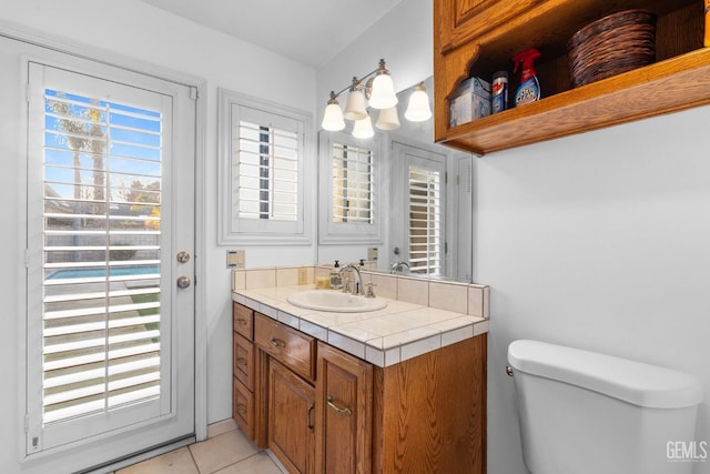 half bath featuring toilet, vanity, and tile patterned floors