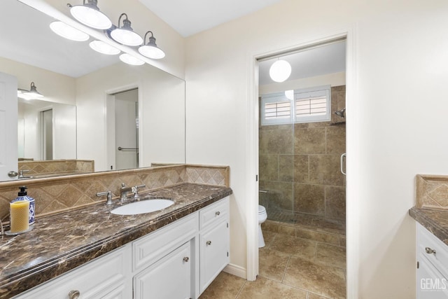 bathroom featuring toilet, tile patterned floors, vanity, a shower stall, and backsplash