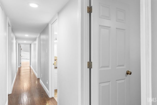 hall with baseboards and wood finished floors