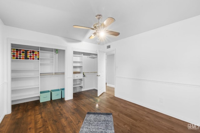 unfurnished bedroom with dark wood-style floors, ceiling fan, visible vents, and baseboards