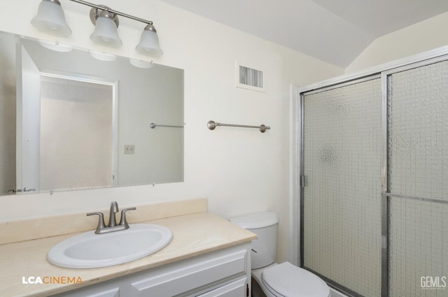 bathroom with a shower with door, vanity, lofted ceiling, and toilet