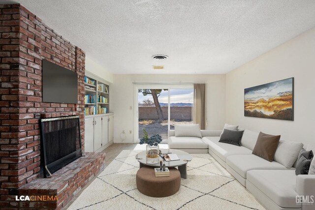 carpeted living room with built in shelves, a textured ceiling, and a brick fireplace