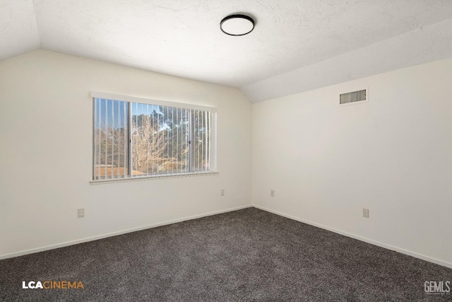 unfurnished room featuring a textured ceiling, carpet, and lofted ceiling