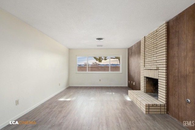 unfurnished living room with a fireplace, hardwood / wood-style floors, and a textured ceiling