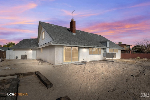 back house at dusk with a patio area and central air condition unit