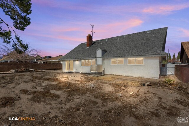 view of back house at dusk