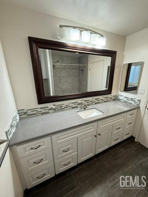 7009 Quailwood Dr, Bakersfield, CA 93309 - bathroom featuring vanity, decorative backsplash, and a tile shower