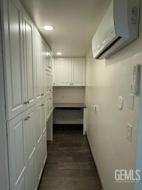 7009 Quailwood Dr, Bakersfield, CA 93309 - corridor with a wall mounted AC, dark wood-style floors, and recessed lighting