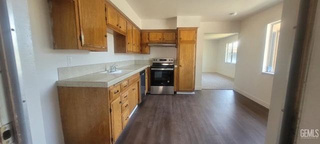 5309 New Grove Ave, Bakersfield, CA 93309 - kitchen featuring stainless steel electric stove, under cabinet range hood, dishwasher, brown cabinets, and dark wood finished floors