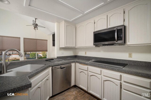 kitchen featuring lofted ceiling, sink, white cabinetry, appliances with stainless steel finishes, and dark hardwood / wood-style floors