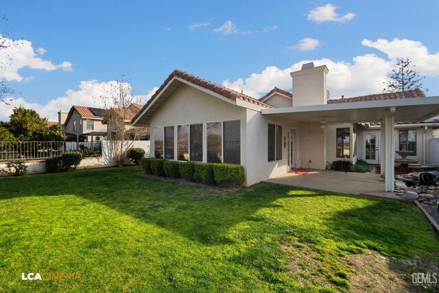 rear view of house with a lawn and a patio area