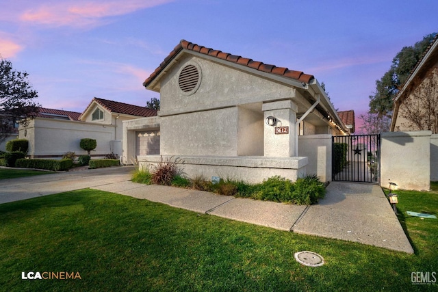 view of front of house with a garage and a lawn