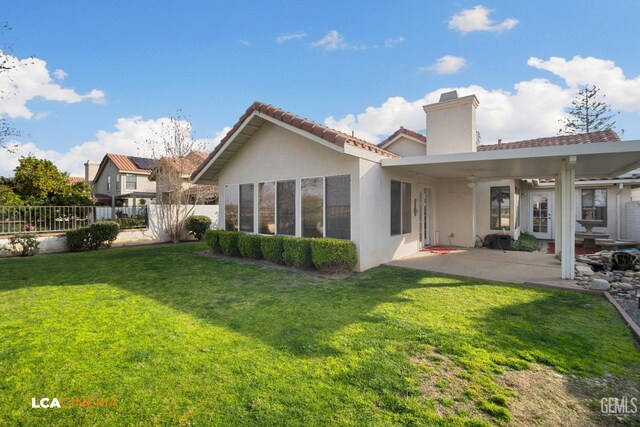 back of property with a lawn and a patio area